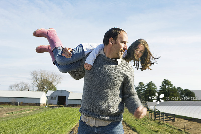 父亲在田野里和女儿（10-12岁）玩耍图片素材