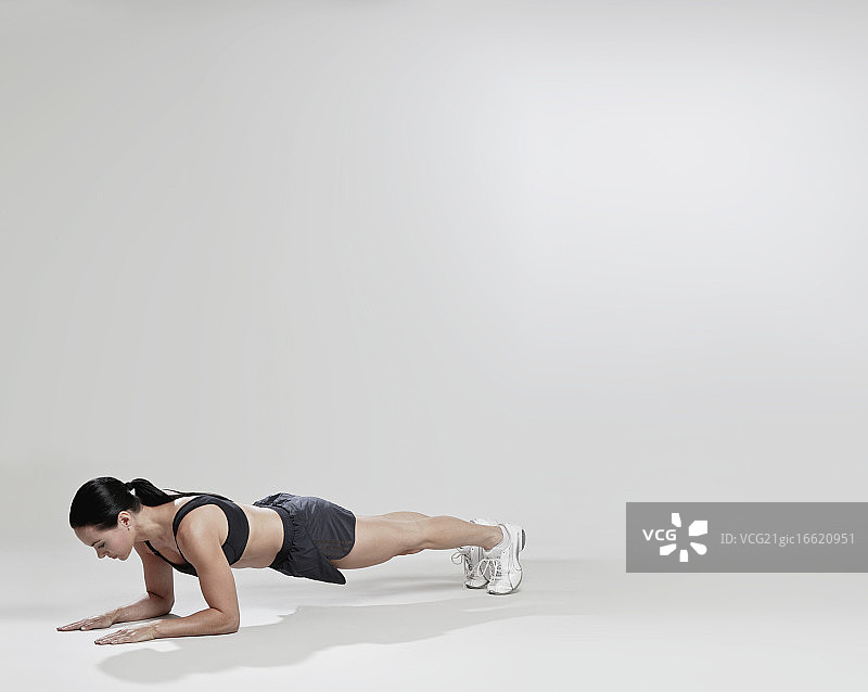 女人保持着平板支撑的姿势图片素材