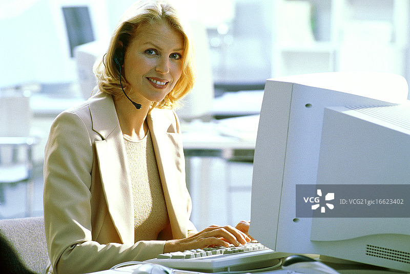 戴着耳机使用电脑的年轻女子图片素材