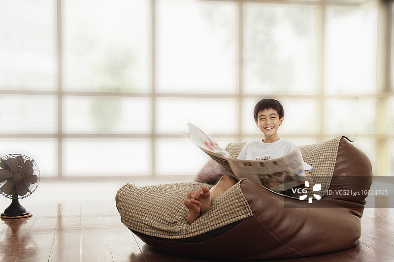 阅读报纸的青少年男孩图片素材