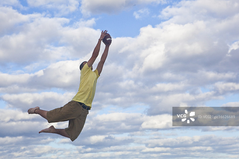 半空中接住橄榄球的青少年图片素材
