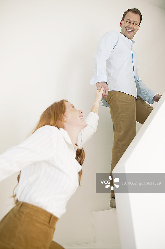 丈夫俏皮地拉着妻子上楼图片素材