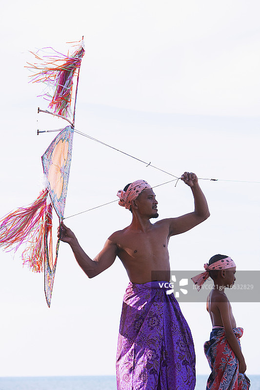 马来西亚父子在海滩上放传统手工风筝图片素材
