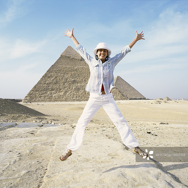 女游客在埃及吉萨金字塔前跳跃图片素材