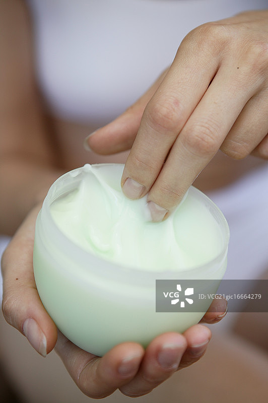 女人的手从罐子里取面霜图片素材