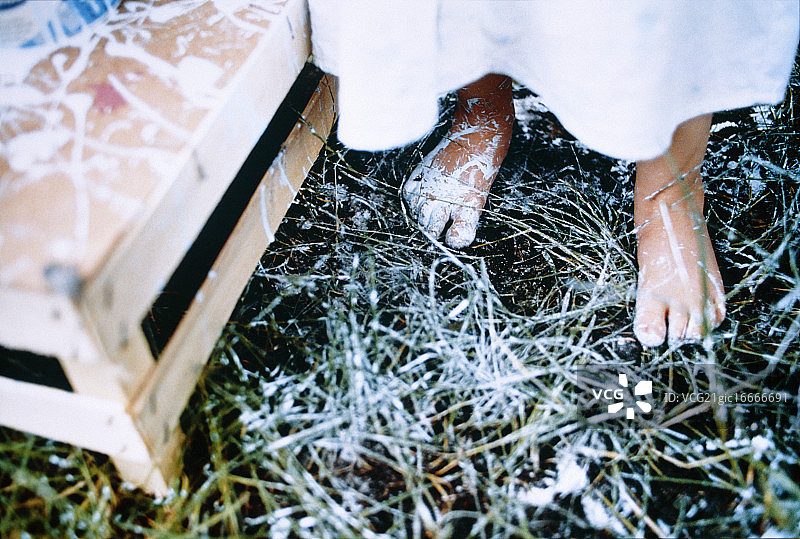 女孩的脚和沾满油漆的草地图片素材