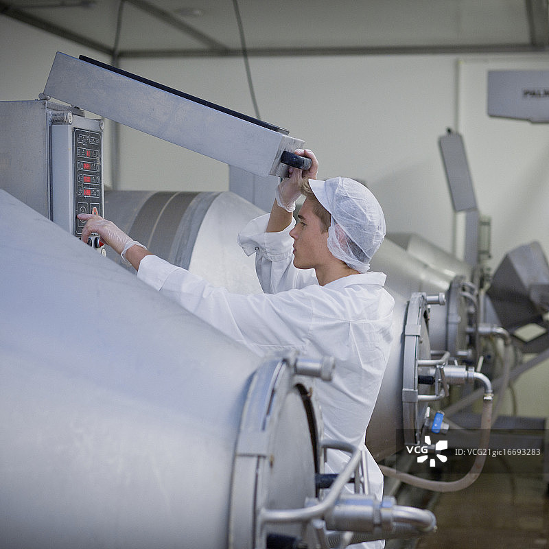 肉类加工厂工人调整设备图片素材