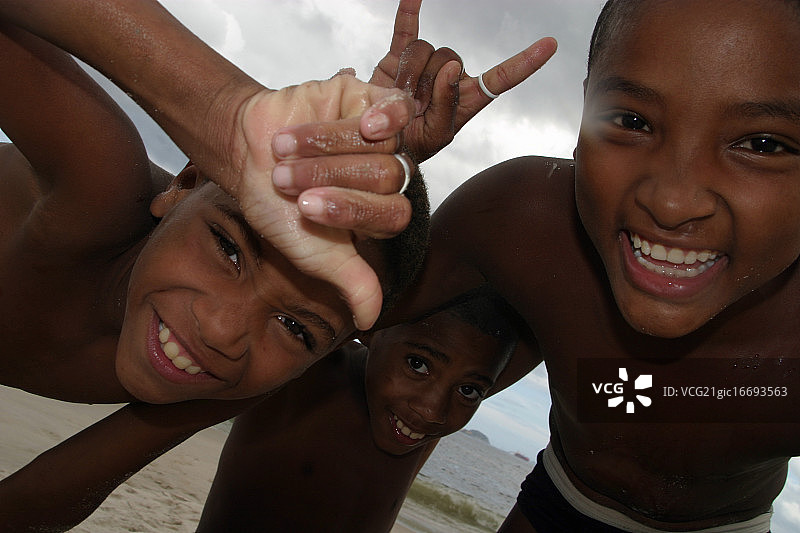 三个笑着并用手势表达的男孩图片素材