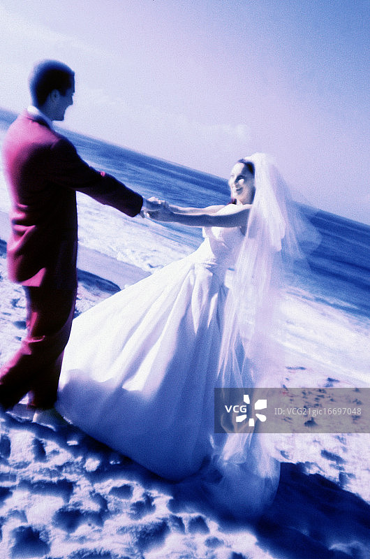 在海滩上跳舞的新婚夫妇图片素材