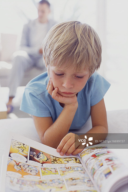 男孩在读漫画书图片素材