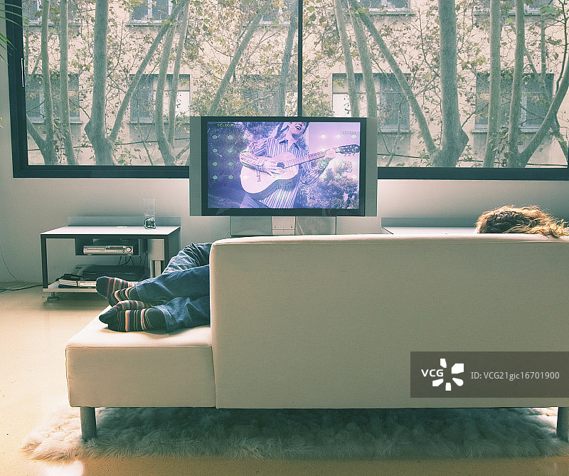 情侣在沙发上看电视放松图片素材