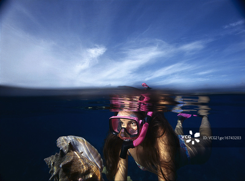 女人在巴哈马新普罗维登斯岛附近浮潜，靠近海螺图片素材