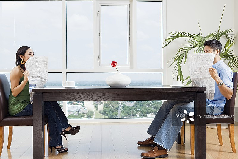 情侣在报纸后互相窥视图片素材