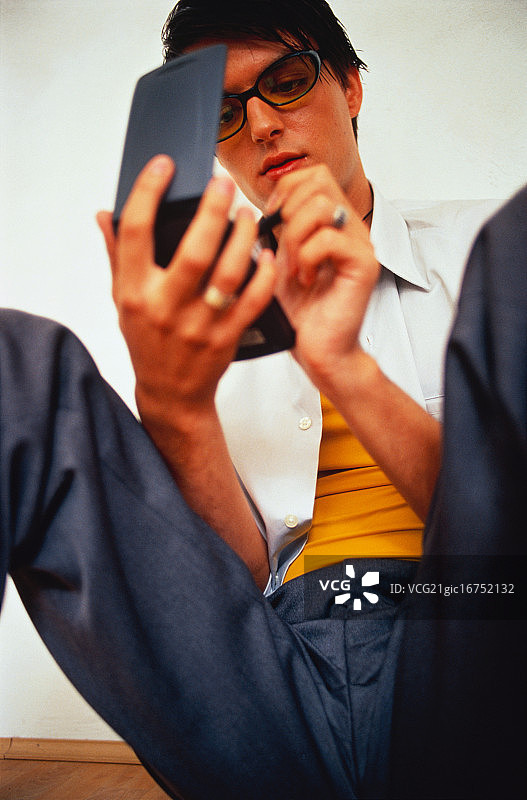坐在地板上手拿掌上电脑的年轻男人图片素材