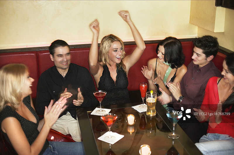 朋友们在桌旁为女人鼓掌图片素材