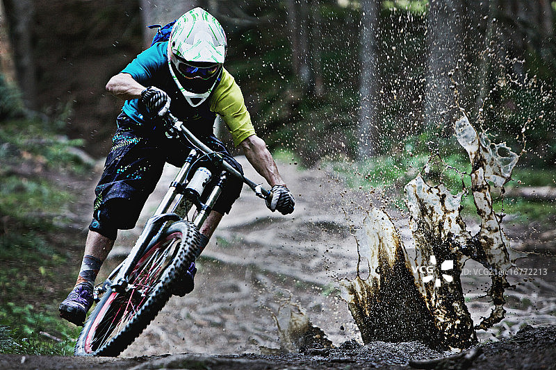 骑自行车的人在泥泞的小路上骑行图片素材
