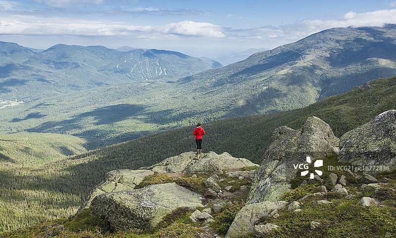 年轻女子独自站在美国新罕布什尔州白山岩石上图片素材