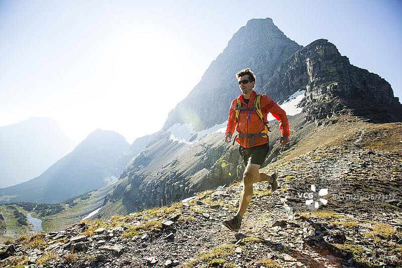 男人在冰川国家公园的落基山脉小路上跑步图片素材