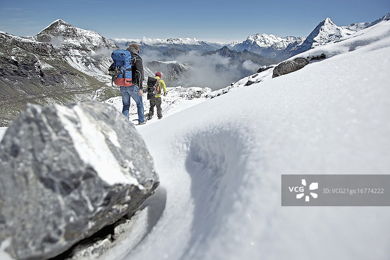 两名男子在伯尔尼阿尔卑斯山脉的雪地上行走图片素材