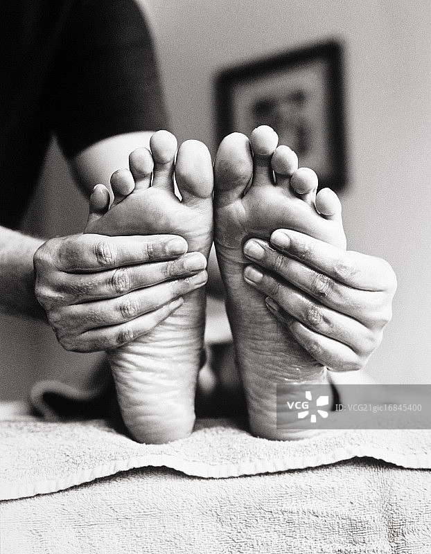 按摩女性双脚的手图片素材