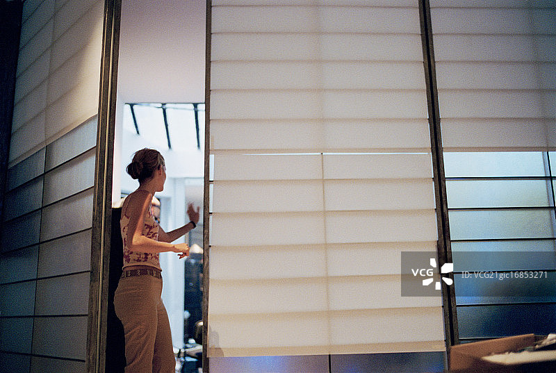 女人在门口向里面的人挥手图片素材