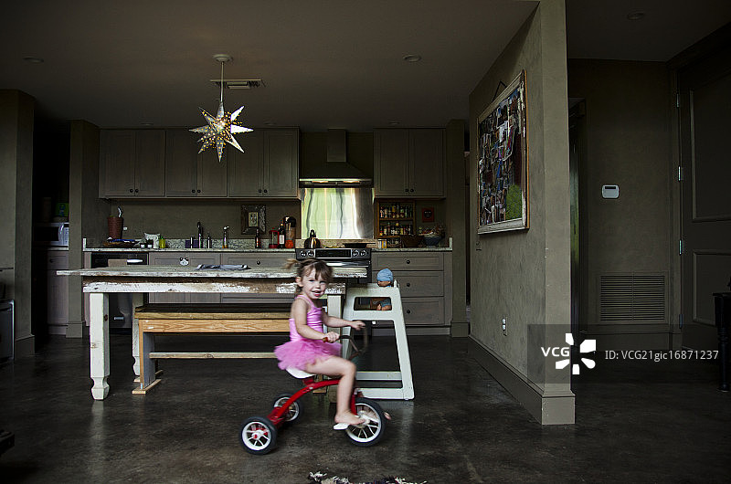在厨房里骑自行车的女孩（4-5岁）图片素材