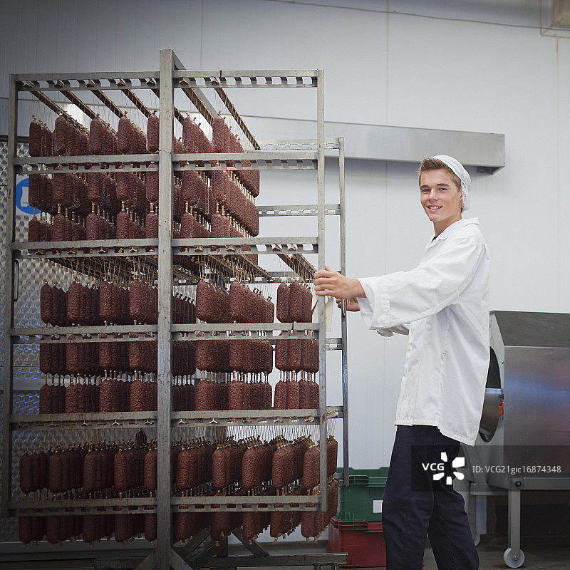 年轻的肉类加工厂与一架香肠图片素材