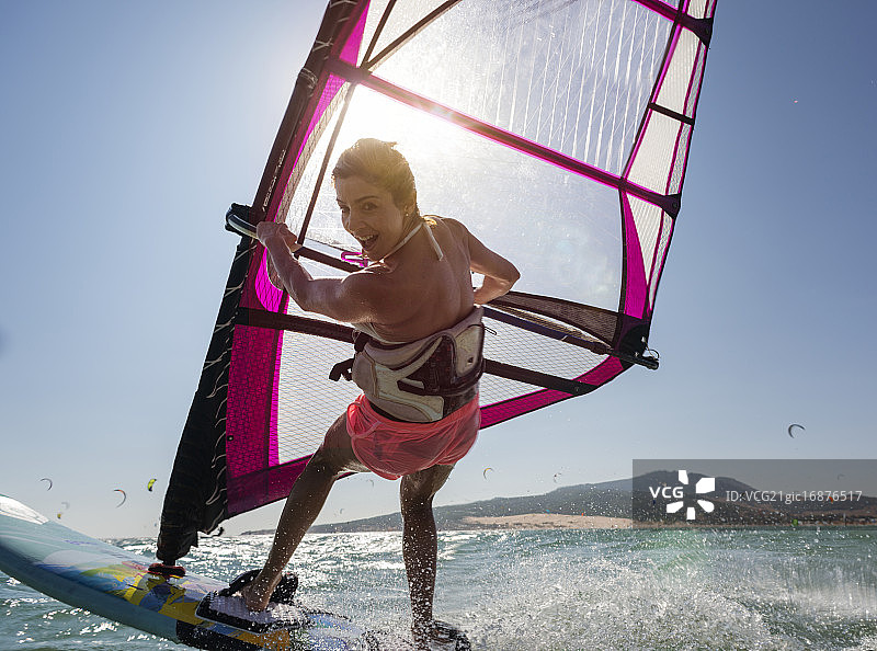 年轻女子在玩帆板冲浪，享受乐趣图片素材
