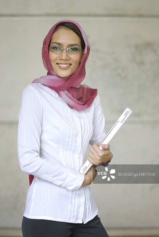 携带笔记本电脑的马来西亚穆斯林妇女图片素材