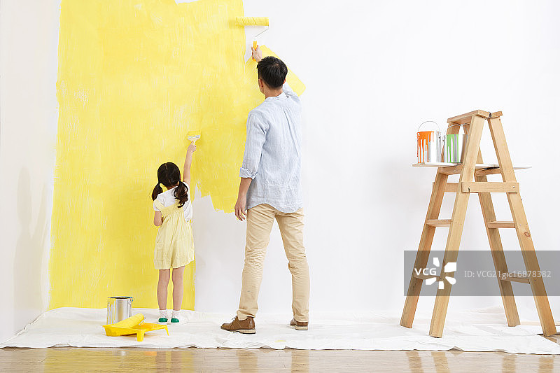 欢乐的父女在为墙壁涂染料图片素材
