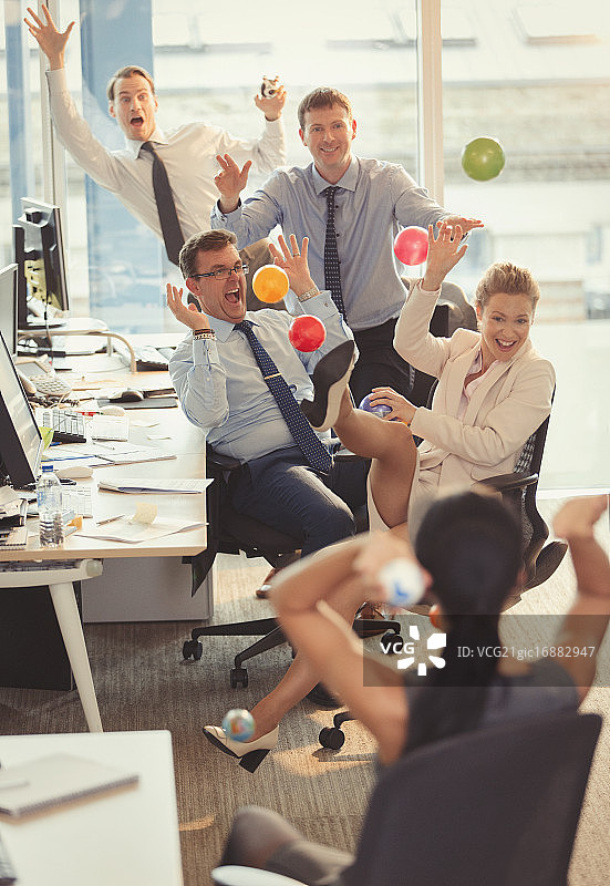 在办公室互相投掷彩色塑料球的商务人士图片素材