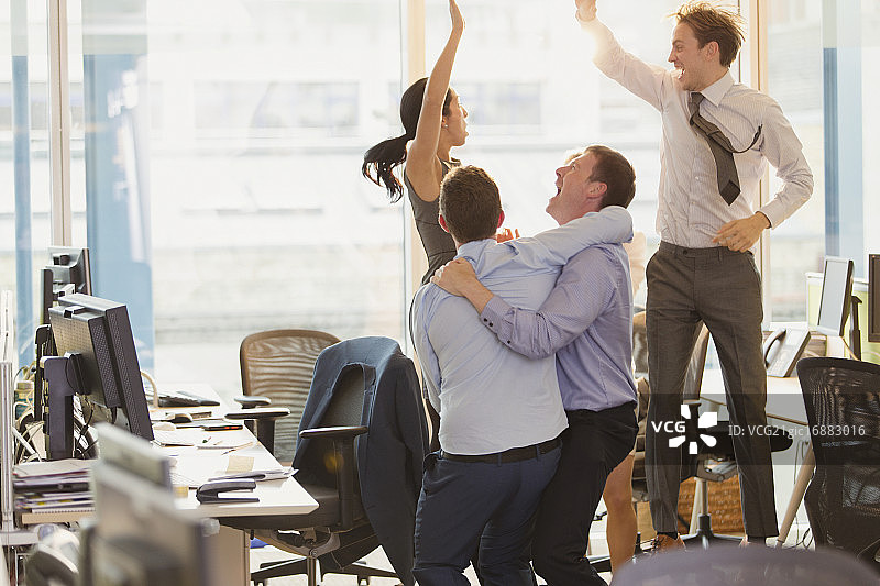 充满活力的商人在办公室庆祝和跳跃图片素材