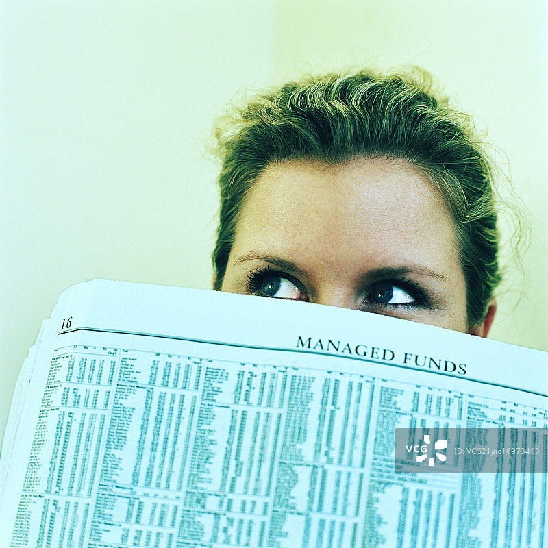 女子从报纸后探出头图片素材