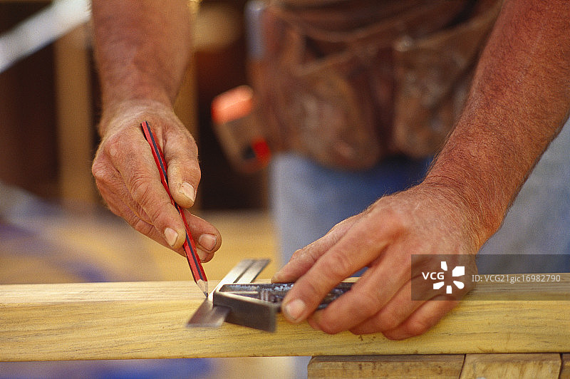 男子在建筑工地用铅笔和尺子图片素材