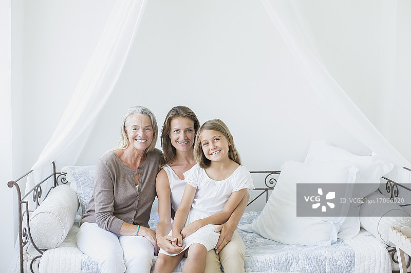 在沙发床上微笑的多代女性图片素材