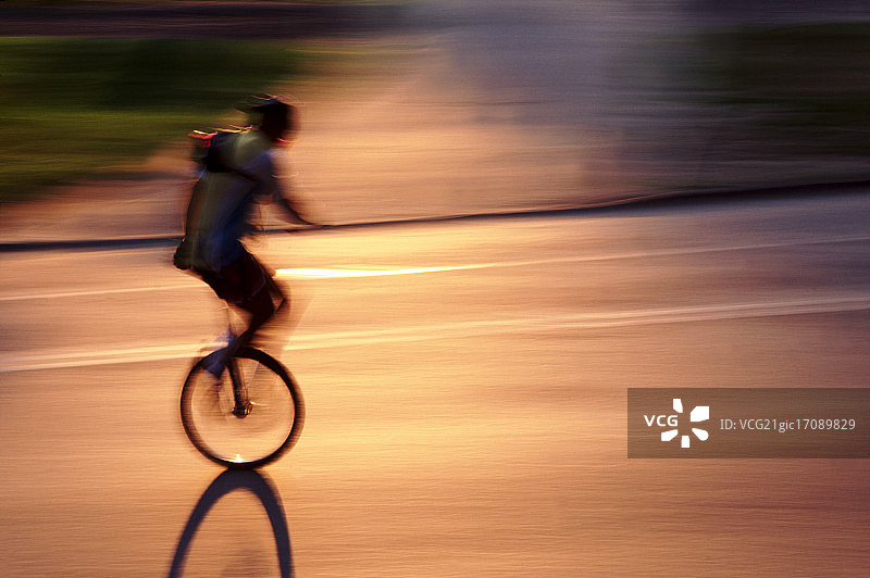 夕阳下的单轮车骑行者图片素材