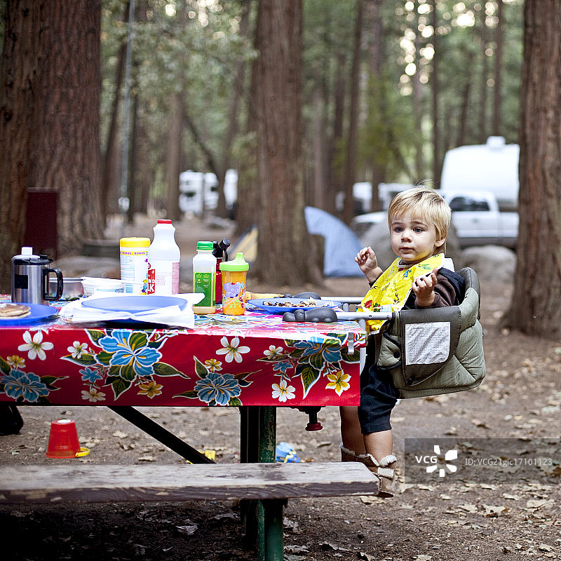 坐在野餐桌儿童座椅上的男孩图片素材