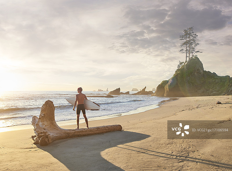 在石狮海滩上的冲浪者图片素材