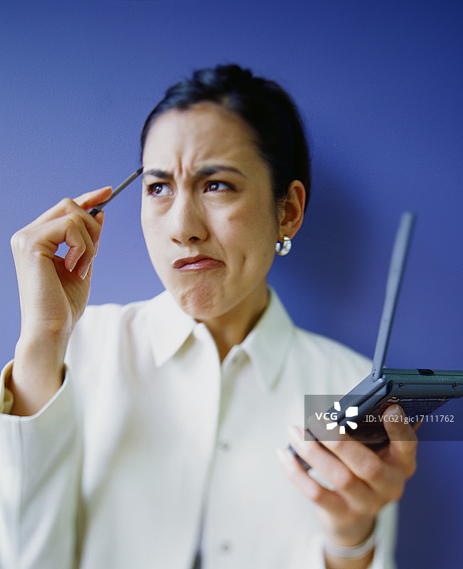 困惑的女商人使用掌上电脑图片素材