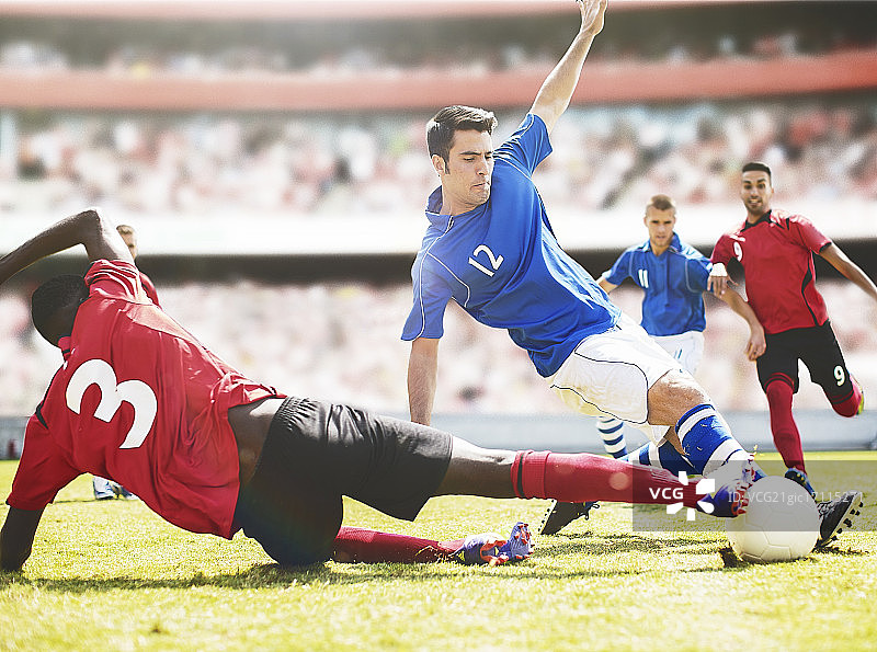 足球运动员在球场上踢球图片素材