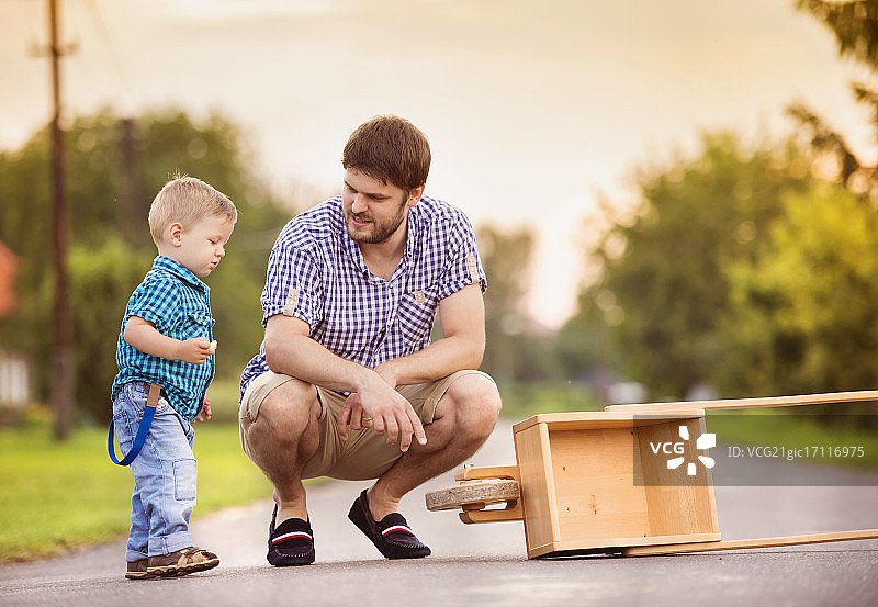 父子在路上推着手推车图片素材