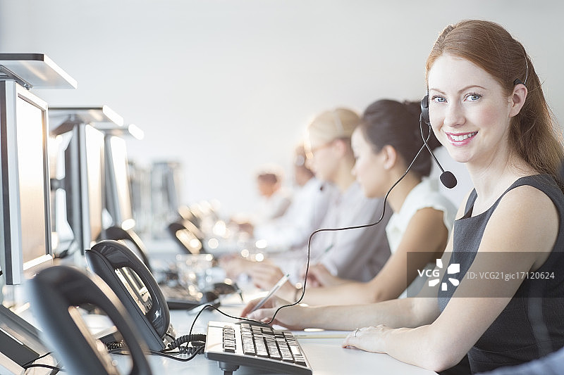 在办公室戴耳机的商务女人图片素材