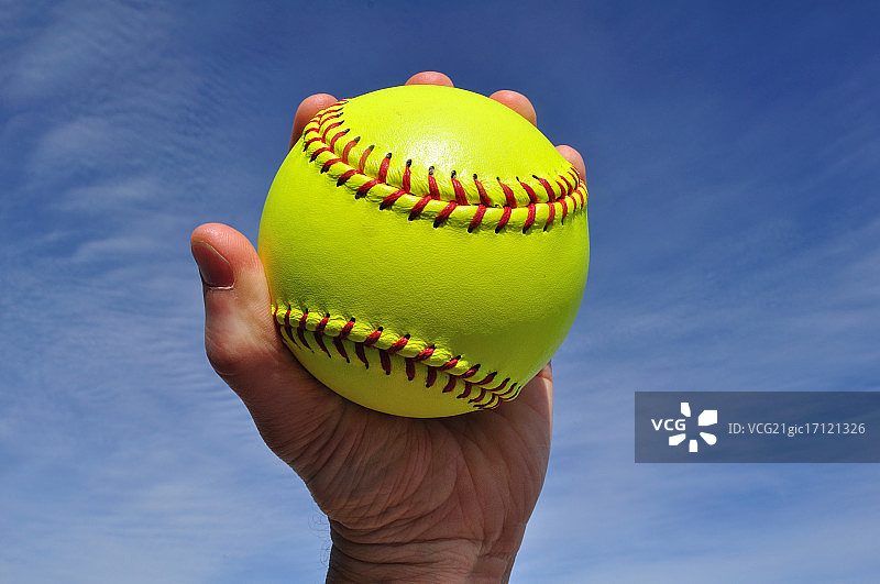 手握黄色垒球的男人图片素材