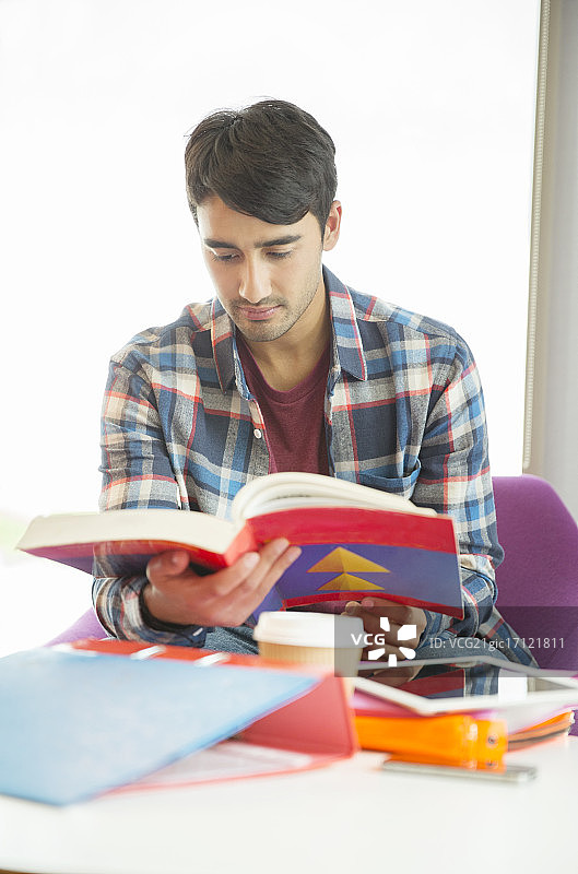 大学生在休息室阅读课本图片素材
