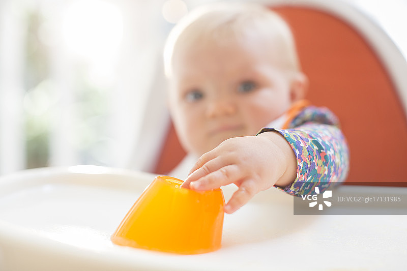 坐在高脚椅上吃东西的女婴图片素材