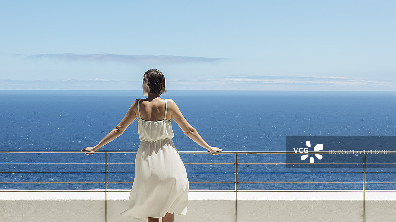 女人在阳台上眺望大海图片素材