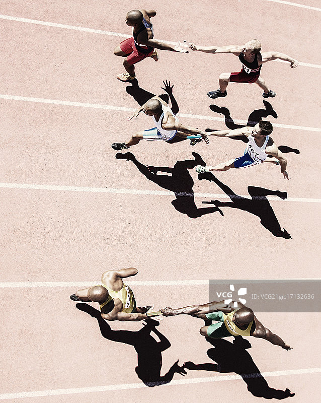 接力赛跑者在赛道上交接棒图片素材