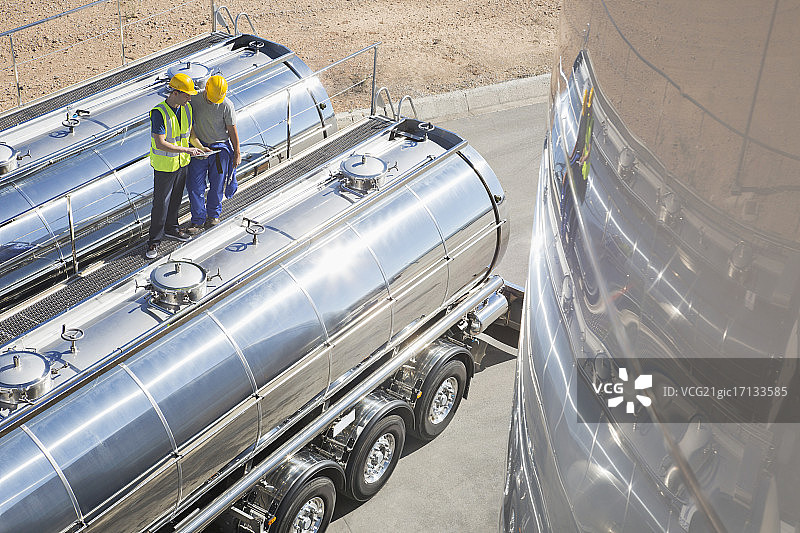 工人在不锈钢牛奶罐车上方的平台上工作图片素材
