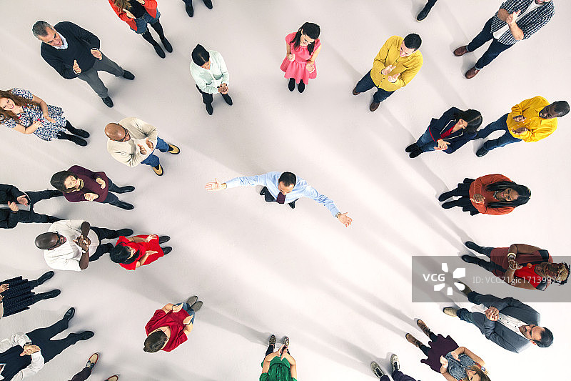 张开双臂的商人周围的人群图片素材