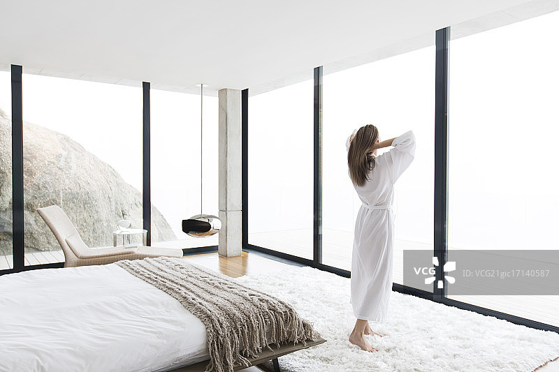 在现代卧室里穿着浴袍的女人图片素材
